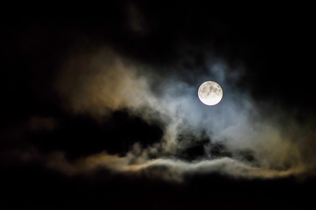 Full moon surrounded by clouds.