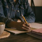 Person writing in a notebook.