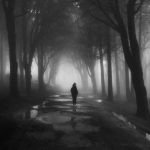A woman walking alone on a foggy night.