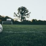 Soccer ball on empty field as sun sets
