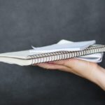 Person holding blank notebooks