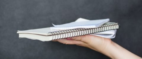 Person holding blank notebooks