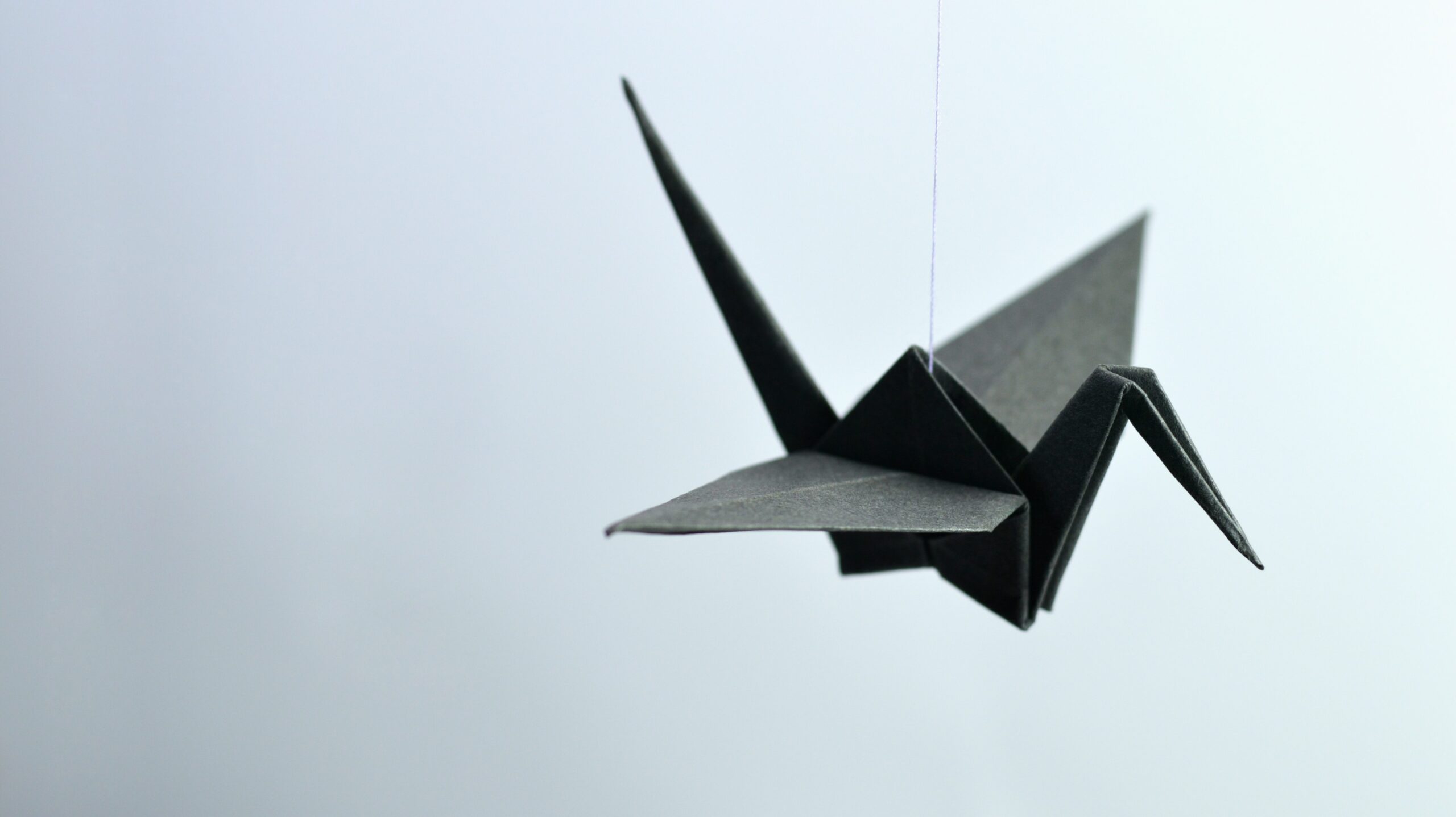 A paper origami bird hanging from a string