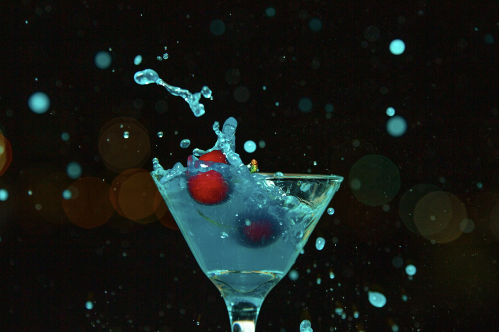 Cherries splashing into a martini