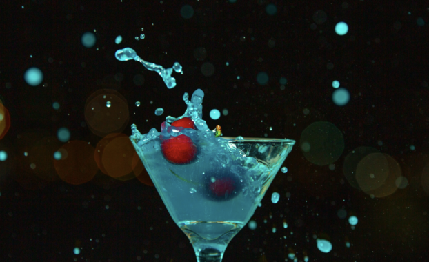 Cherries splashing into a martini