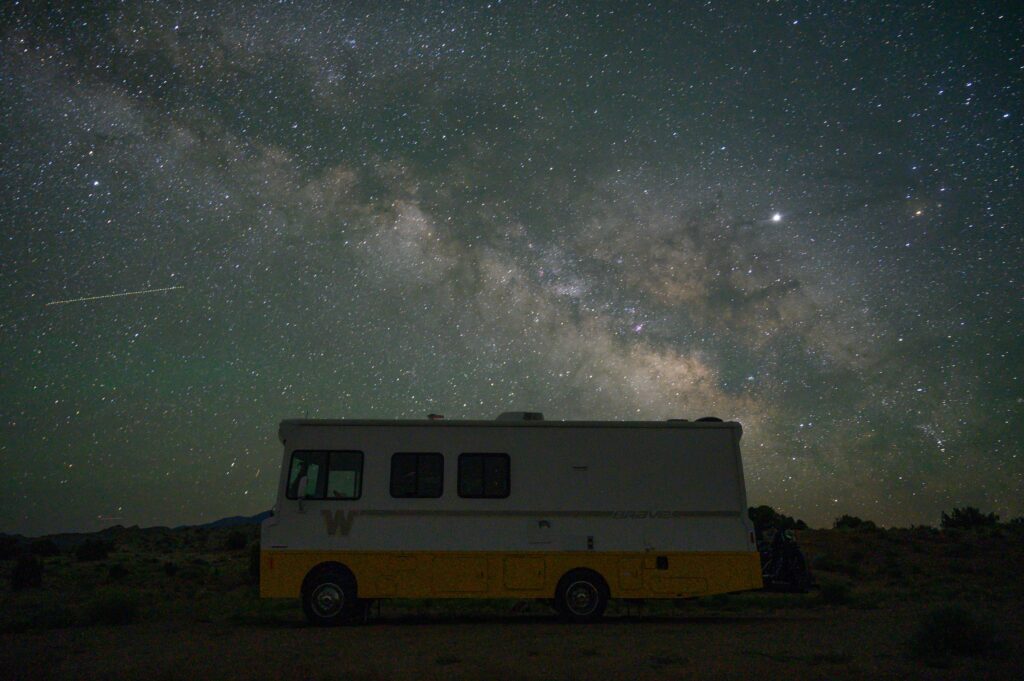 An RV under the star filled night sky
