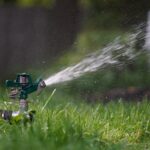 A sprinkler spraying water onto green grass