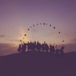 Silhouette of people throwing graduation caps