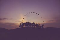 Silhouette of people throwing graduation caps